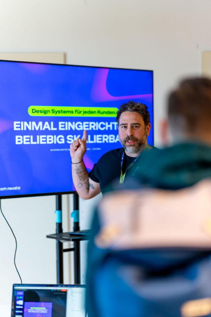 Session Host präsentiert vor einem Bildschirm